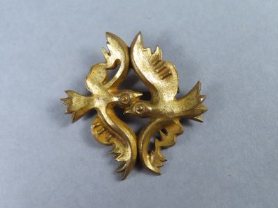 une broche en or ornée de deux oiseaux