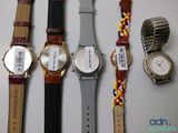 several watches are lined up on a table with a price tag on them