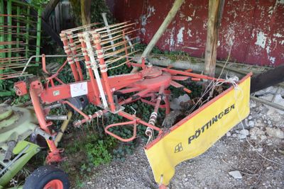 a red tractor with a yellow plow attached to it