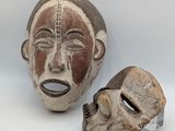 two masks are sitting next to each other on a white surface