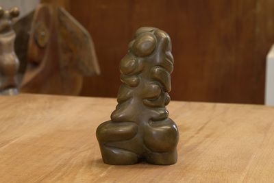 une statue de femme tenant un enfant sur une table