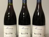 three bottles of wine are lined up on a table