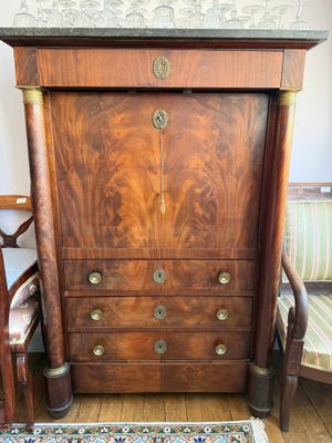 une commode en bois avec des tiroirs et un tapis posé au sol