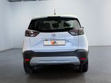 the rear end of a white car parked in a garage