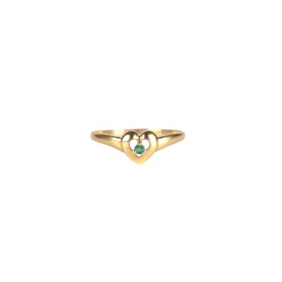 gros plan d'une bague en or avec une pierre verte