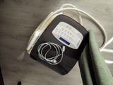 a black and white electronic device on a table next to a green blanket