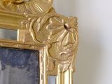 a mirror with a gold frame on the wall
