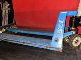 a blue hand truck with a red wall behind it