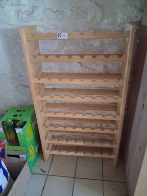 a wooden wine rack with bottles on it in a room