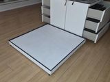 a white platform bed in the middle of a room
