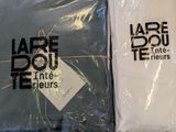 two t - shirts wrapped in plastic bags on a table