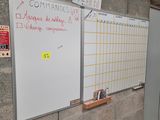 un tableau blanc accroché au mur à côté d'une porte