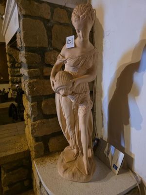 une statue de femme tenant un bébé sur une table
