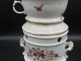 a stack of three white dishes with gold trims