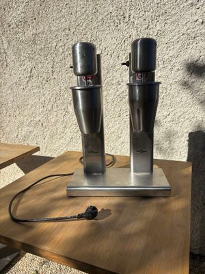 deux machines à café posées sur une table sur laquelle se trouve une tasse