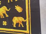 a black and yellow scarf with elephants on it