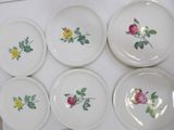 six bowls with roses painted on them sit on a white surface