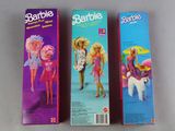 two boxes of barbie dolls sitting on top of a table