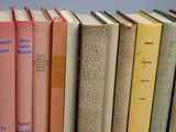 several books are lined up in a row on a white surface