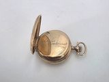 an antique gold pocket watch on a white surface