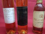 several bottles of wine are lined up on a pink table
