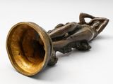 a bronze sculpture of a man laying on a trumpet
