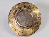an image of a gold plate sitting on top of a white table