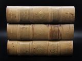 trois vieux livres empilés les uns sur les autres sur une surface noire
