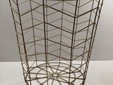 a close up of a metal basket on a white surface