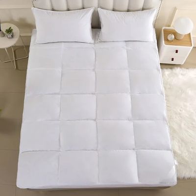 a close up of a bed with a white comforter on top of it