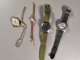 trois montres et un bracelet sont posés sur une table
