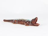 a toy alligator that is laying down on a white surface