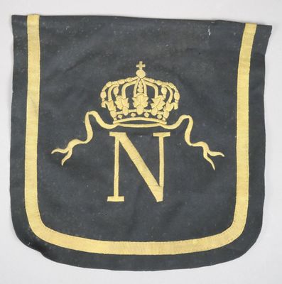 un gros plan d'un drapeau noir et or orné d'une couronne
