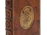 un vieux livre relié en cuir, orné d'un médaillon doré sur la couverture