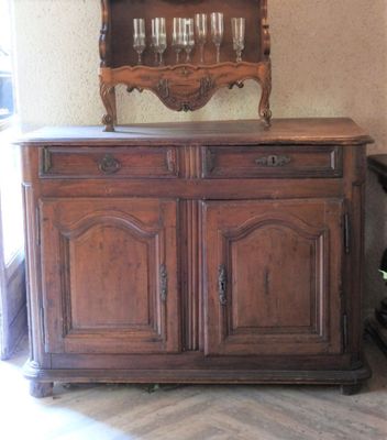 a wooden cabinet with wine glasses on top of it