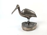 figurine de pélican plaquée argent sur socle, sur fond blanc