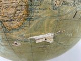 a close up of a small globe on a wooden stand