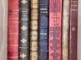 several old books are in a cardboard box on a table