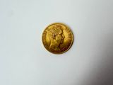 gros plan d'une pièce d'or sur une surface blanche