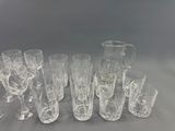 a lot of glasses and a pitcher sitting on a table