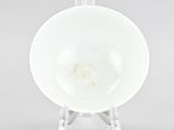 underside view of a white bowl on a clear stand