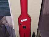 a red guitar case sitting on the wall next to a metal counter