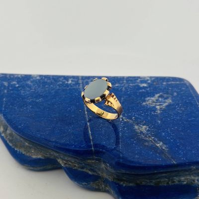 a close up of a gold ring with a blue stone on it