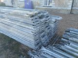 un tas de poteaux métalliques posés dans l'herbe