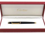 un stylo noir et doré posé dans une boîte rouge