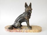 statue en bronze représentant un chien assis sur un socle en marbre