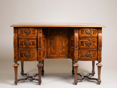 un bureau ancien en bois, muni de trois tiroirs et d'un plateau en marbre