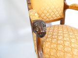 une chaise en bois ornée d'une tête de lion