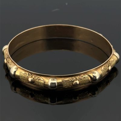 un bracelet rigide ancien en or, orné d'un motif gravé