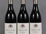 three bottles of wine are lined up on a table